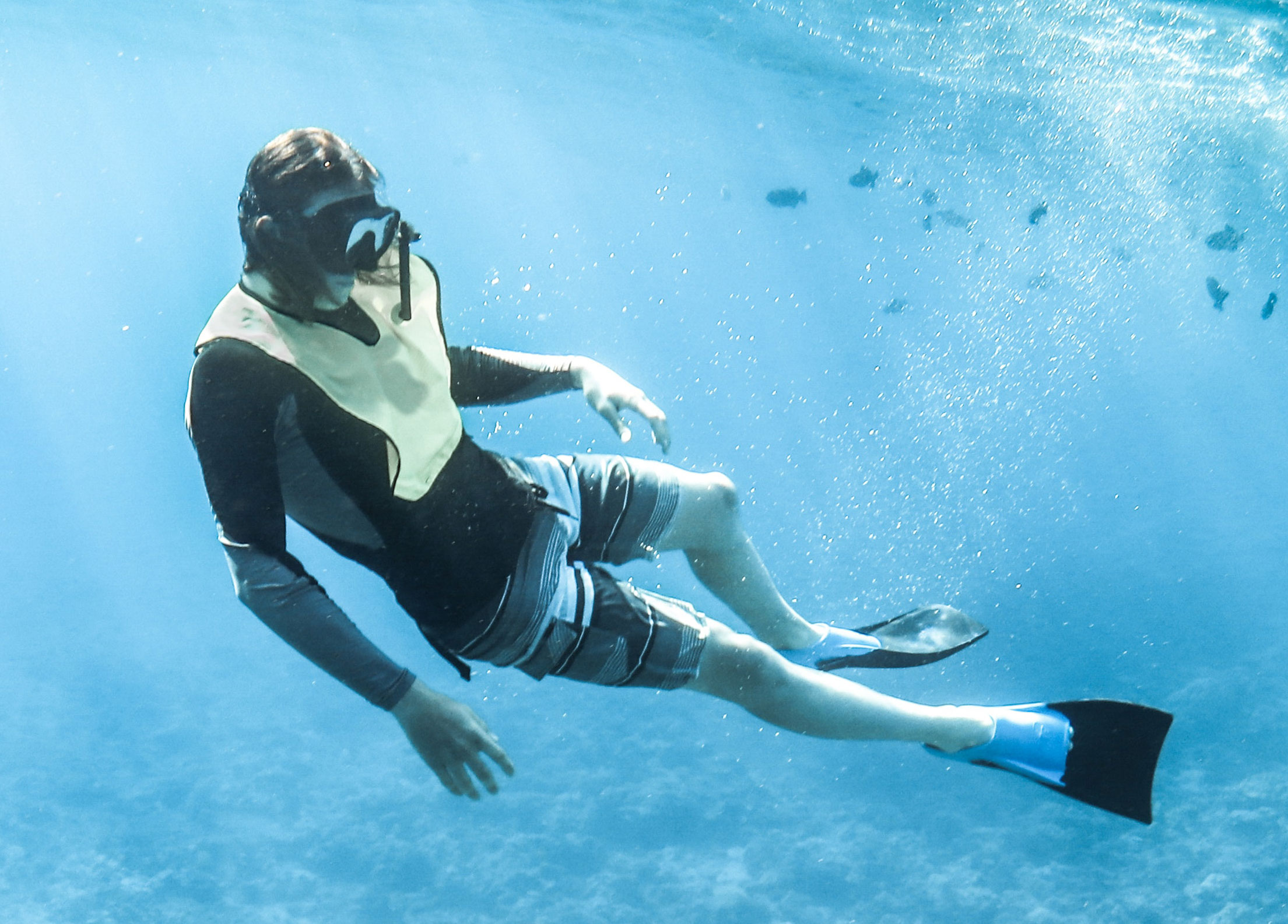 A snorkeler wearing a snorkel vest underwater